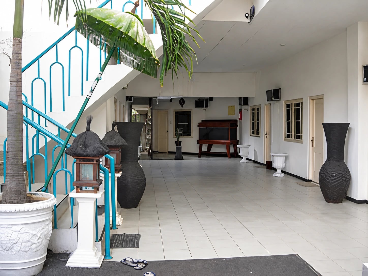 Area bersama yang terbuka dengan tanaman dan tangga di Kost Menteng