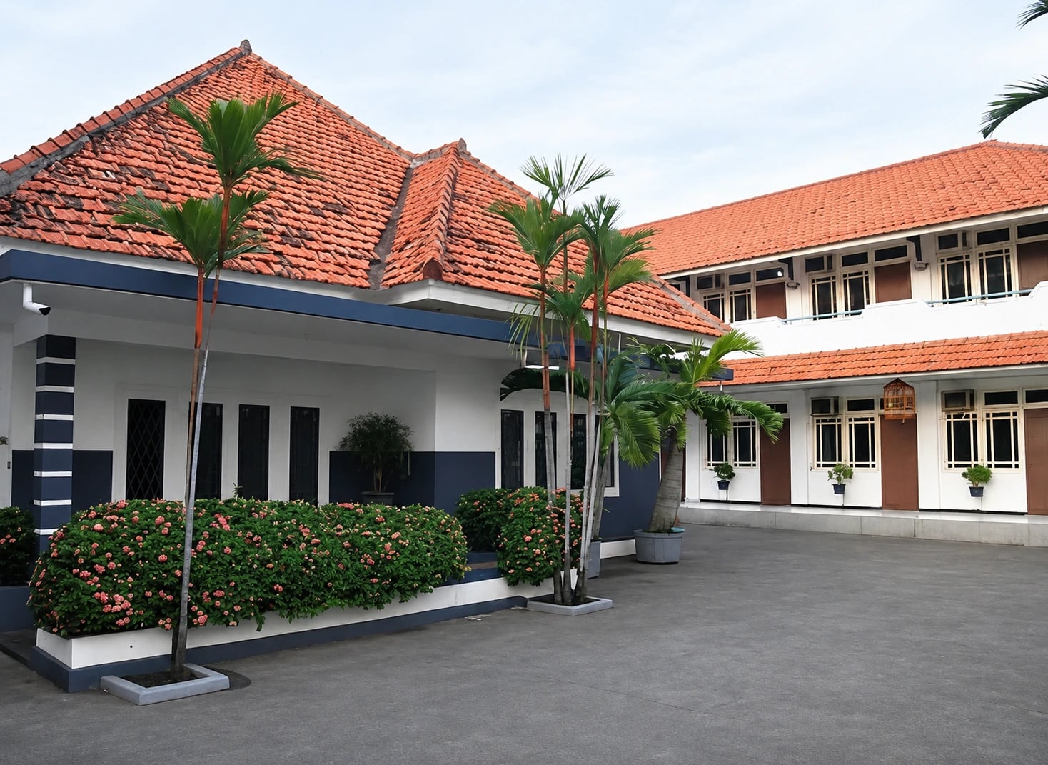Halaman Kost Menteng dengan bangunan beratap terakota dan tanaman hijau